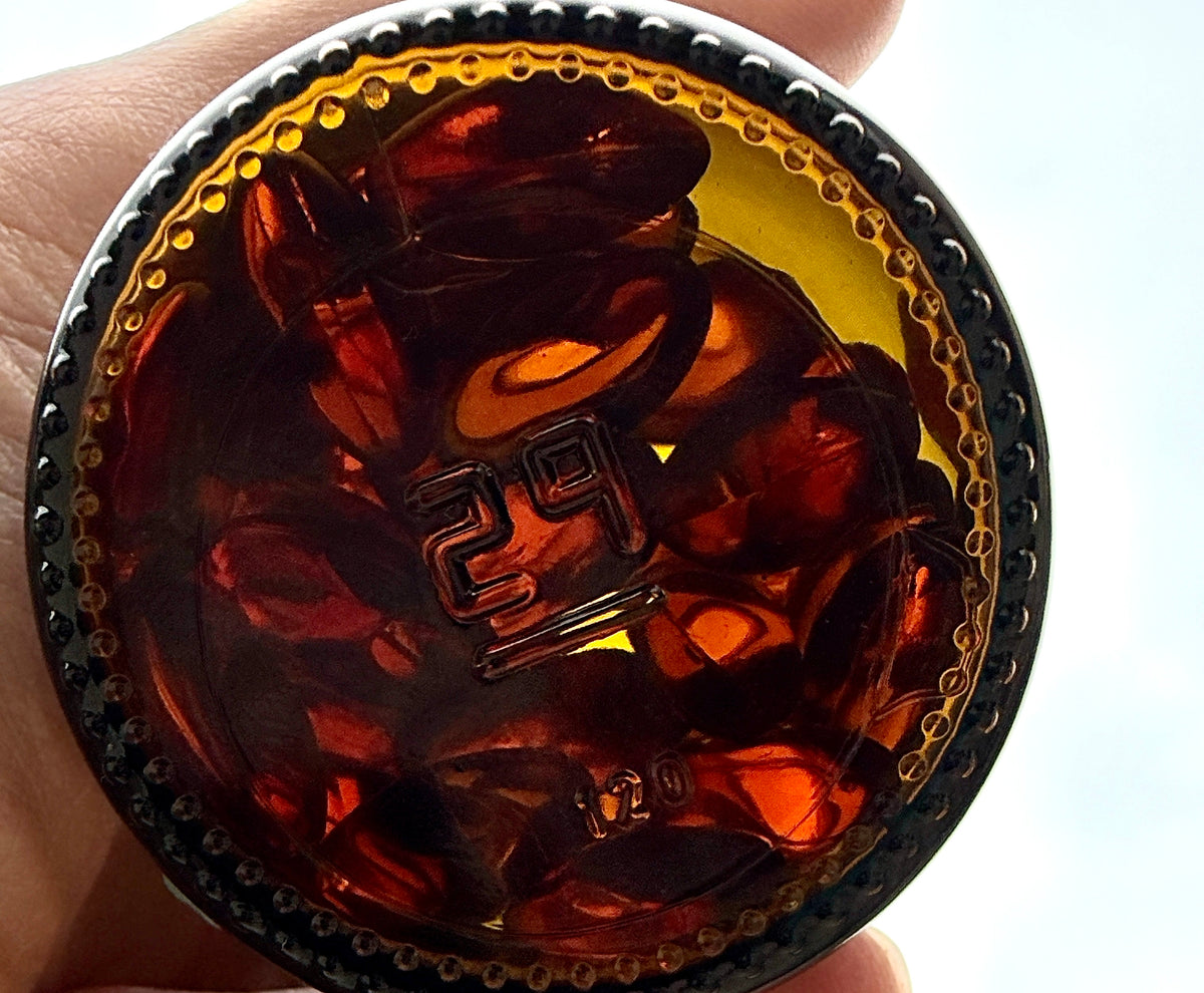 Top-down view of a Truemeric bottle filled with orange softgels